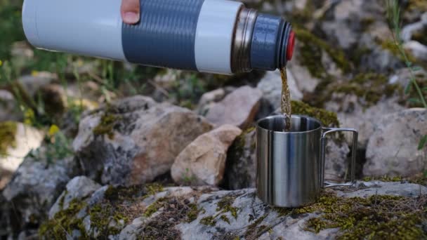 户外和远足的概念 温暖的茶从带有自然背景的热水瓶中喷出 模糊不清 在大自然中度过时光 徒步旅行期间的休息 — 图库视频影像