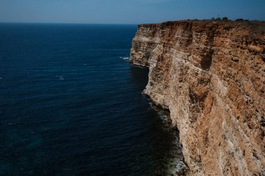 Mavi denizdeki uçurumdan güzel bir manzara. Denizde serbest kayalıkları olan inanılmaz bir sahil. Cape Fiolent, Kırım.