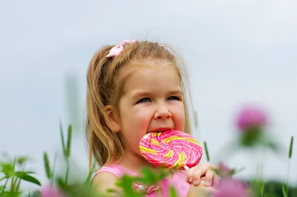 Маленькая девочка ест леденец — стоковое фото