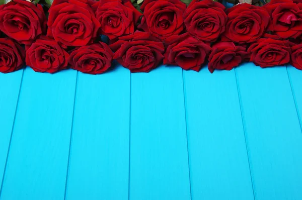 Rose rosse fiori su legno blu . — Foto Stock