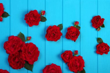 Kırmızı gül çiçekler mavi ahşap üzerine.
