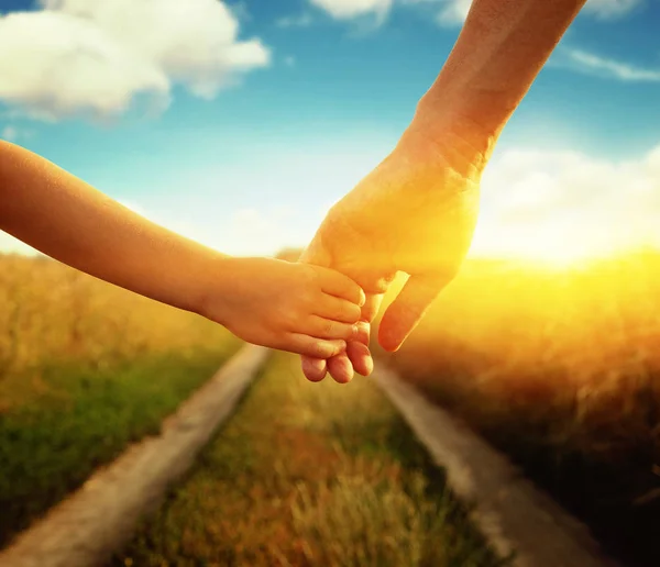 Hands of holding each other in field — Stock Photo, Image