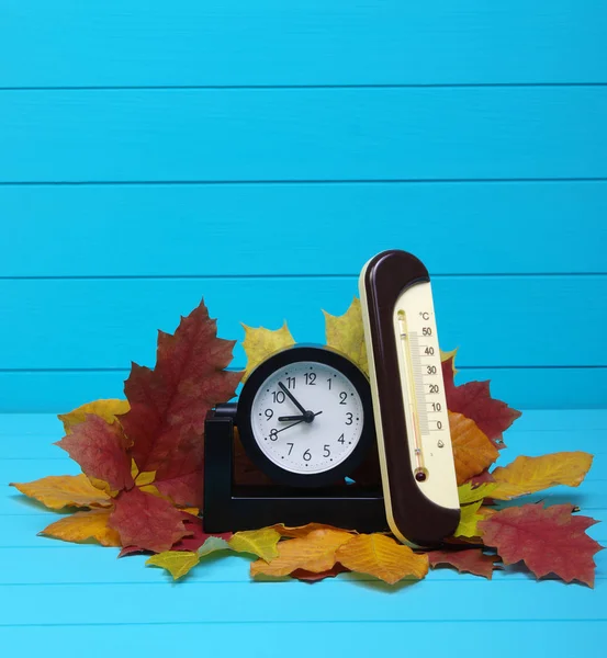 Podzimní listí a budík na dřevo — Stock fotografie
