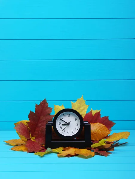 Podzimní listí a budík na dřevo — Stock fotografie