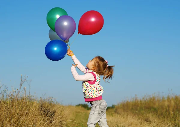 Meisje buiten met ballonnen — Stockfoto