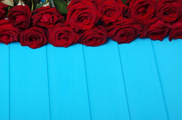 Flores de rosas vermelhas em madeira azul . — Fotografia de Stock