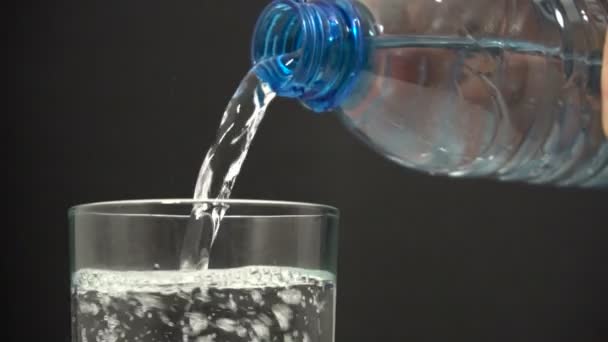병에서 유리병으로 물을 퍼내는 모습 — 비디오
