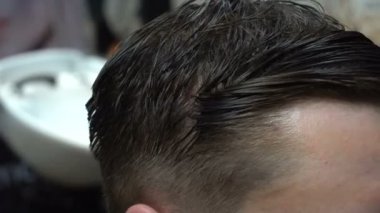 Bir kuaföre tıraş olan bir adam.