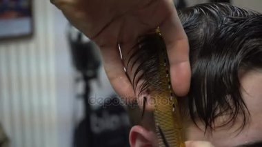 Bir kuaföre tıraş olan bir adam.