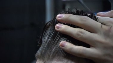 Bir kuaföre tıraş olan bir adam.