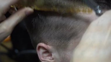 Bir kuaföre tıraş olan bir adam.