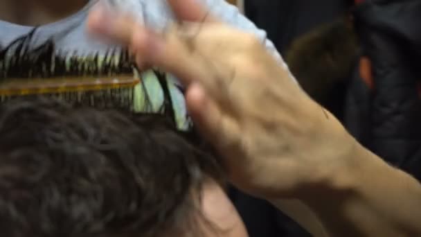 Man krijgt een kapsel door een kapper — Stockvideo