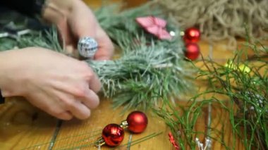 Çiçekçi yapma Noel kapı çelengi.