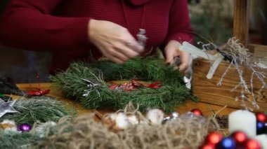 Çiçekçi yapma Noel kapı çelengi.