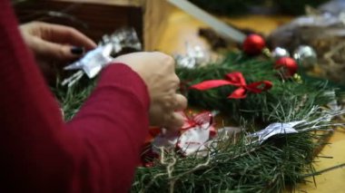 Çiçekçi yapma Noel kapı çelengi.