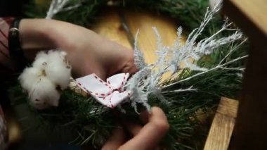 Çiçekçi yapma Noel kapı çelengi.