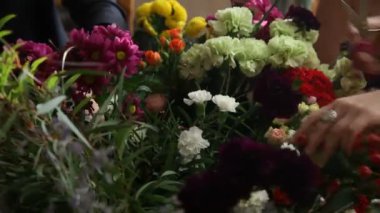 Çiçekçi çiçek buketi için seçtiğiniz iş başında.