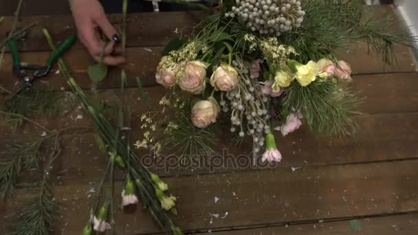 Ανθοκόμος εργασίας τακτοποίηση λουλούδια σε ένα μπουκέτο. — Αρχείο Βίντεο