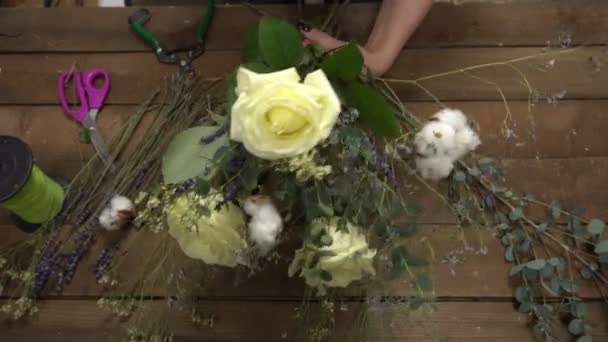 Florista no trabalho organizando flores em um buquê . — Vídeo de Stock