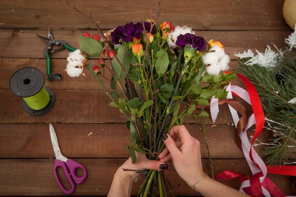 Vrouw bloemist maken winter boeket. — Stockfoto