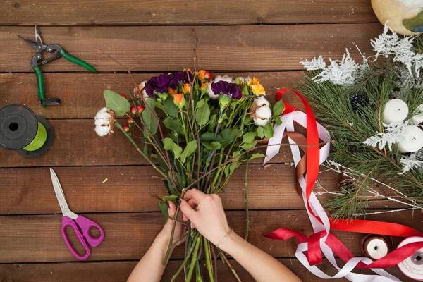 Vrouw bloemist maken winter boeket. — Stockfoto