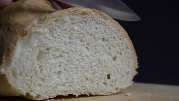 Male hand cutting loaf of bread. — Stock Video