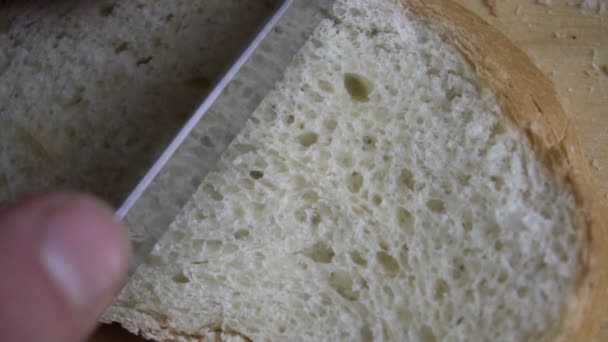 Male hand cutting loaf of bread. — Stock Video