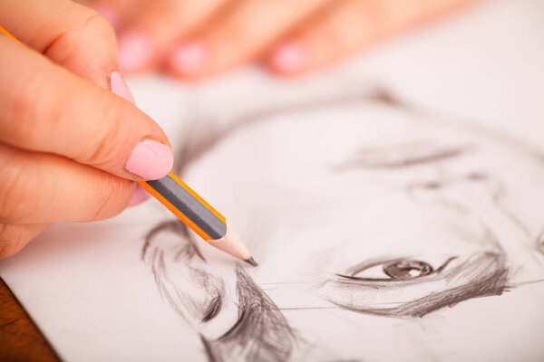 Closeup of drawing mans portrait at the desk