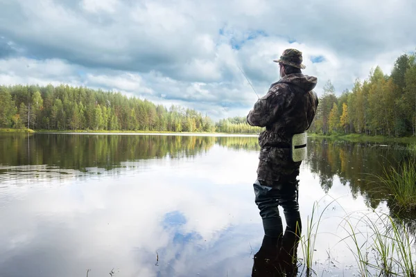 Uomo pesca su un lago — Foto Stock