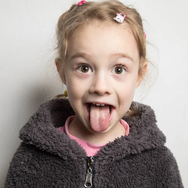 Ευτυχισμένη κοριτσάκι που δείχνει τη γλώσσα της. — Φωτογραφία Αρχείου