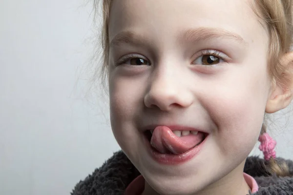 Happy little girl showing her tongue. — Stock Photo, Image