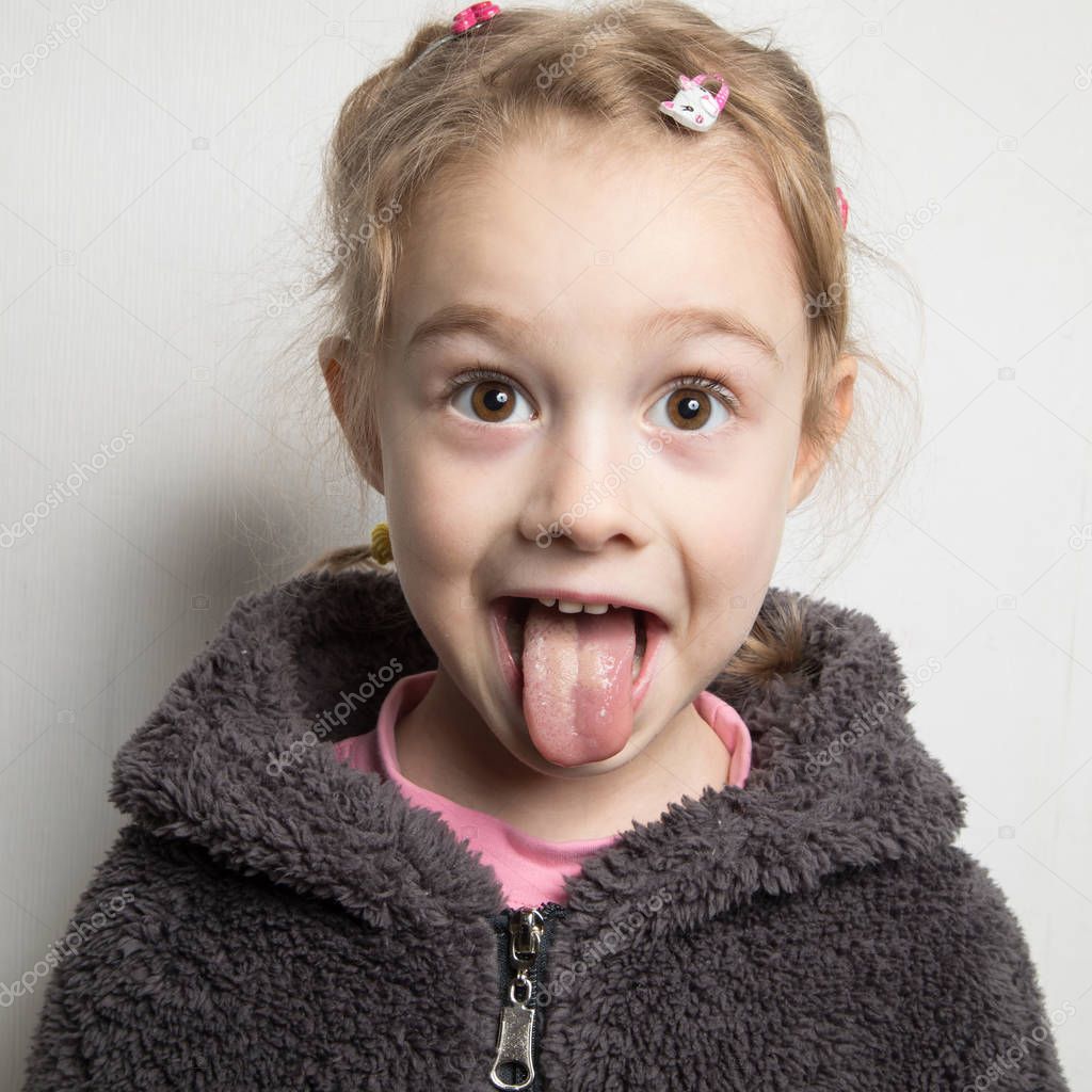 Happy little girl showing her tongue.