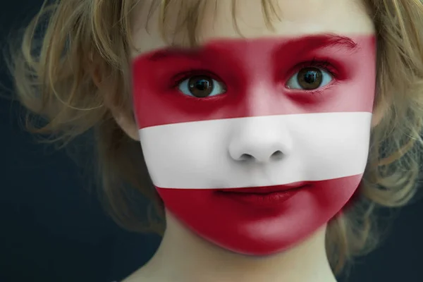 Niño con una bandera pintada de Letonia —  Fotos de Stock