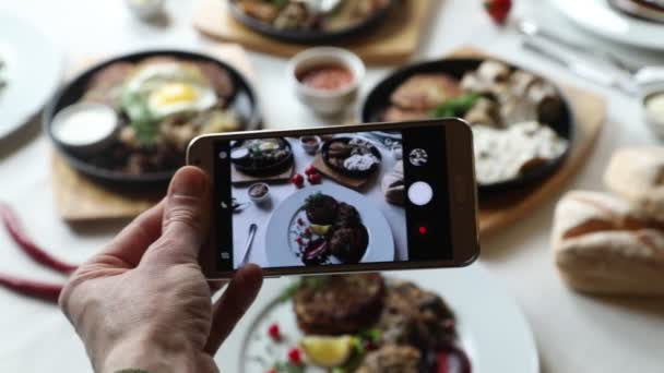 Manos tomando fotos de varios platos con teléfono inteligente — Vídeos de Stock