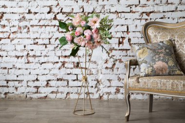 White interior of studio with white and pink flowers.