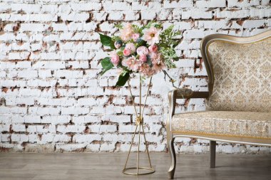White interior of studio with white and pink flowers.