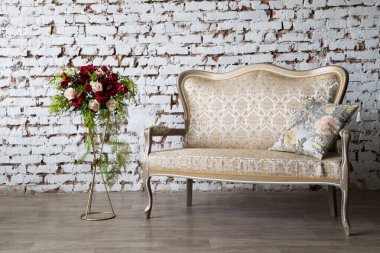 White interior of studio with white and pink flowers.