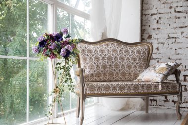 White interior of studio with white and pink flowers.