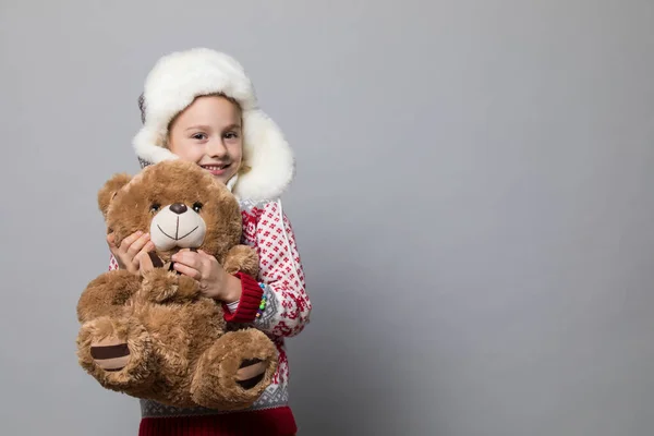 Menina com ursinho de pelúcia na época do Natal — Fotografia de Stock