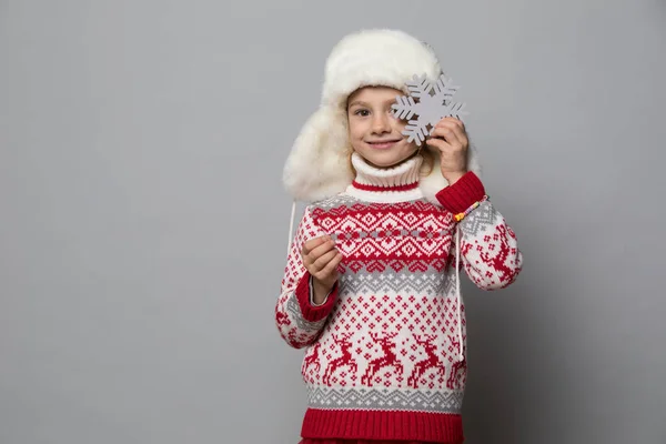 Lächelndes Mädchen im Winterlook auf dem grauen — Stockfoto