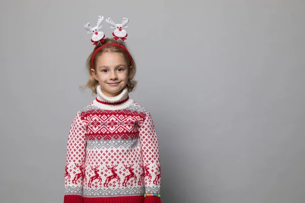 Rolig grabb med julband. Glada leende liten flicka . — Stockfoto