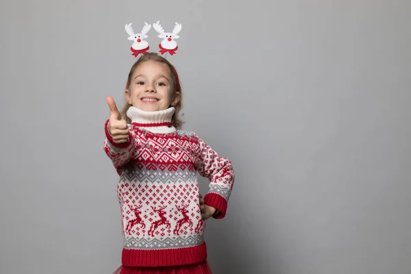 Grappig kind met een kerstband. Vrolijk lachend klein meisje . — Stockfoto