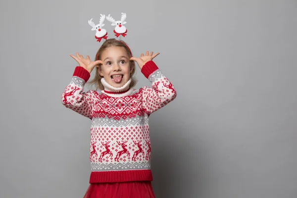 Rolig grabb med julband. Glada leende liten flicka . — Stockfoto