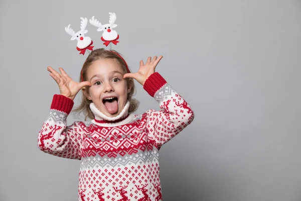 Rolig grabb med julband. Glada leende liten flicka . — Stockfoto