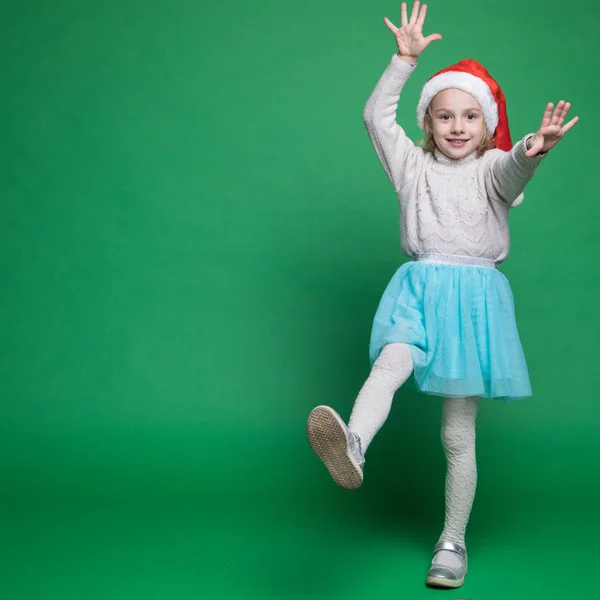 Happy little girl in Santa Claus hat jumping — Stockfoto