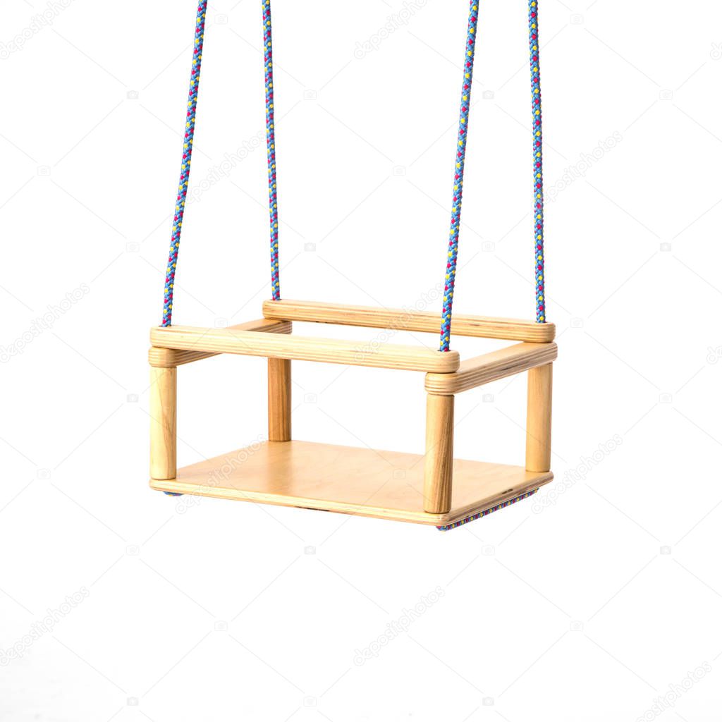 Childrens swing fixed on the ropes on the white .