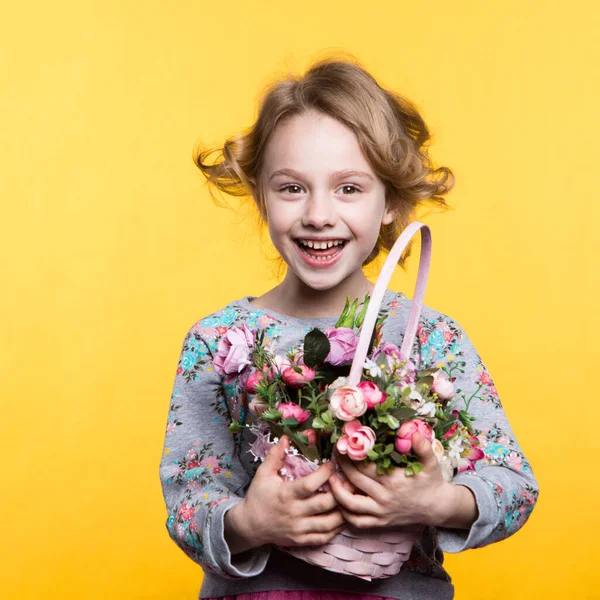 Little smile girl with flowers in basket. — Stockfoto