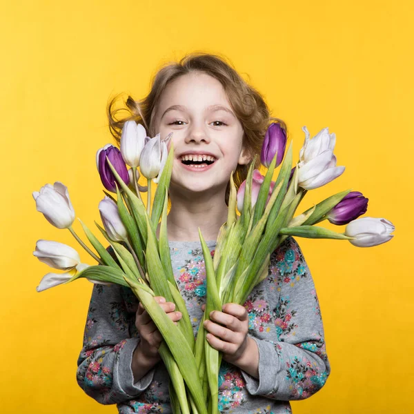 Klein meisje met een boeket tulpen — Stockfoto