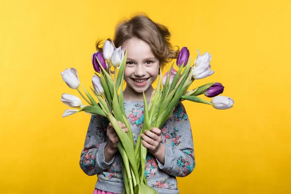 Niña con un ramo de tulipanes —  Fotos de Stock