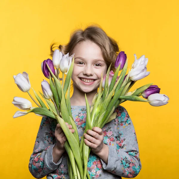 Niña con un ramo de tulipanes —  Fotos de Stock